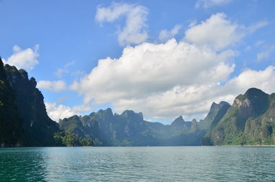 Scenic view of lake by mountains against sky