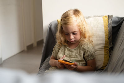 Side view of young woman using mobile phone at home