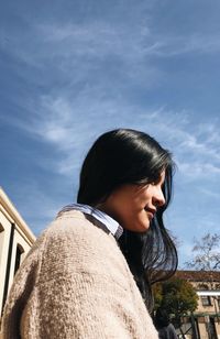 Young woman with black hair against sky