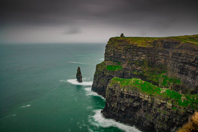 Rock formations by sea against sky