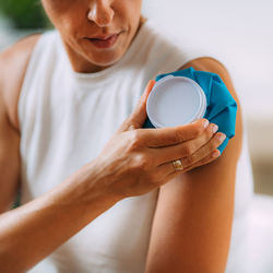 Frozen shoulder. woman holding cold compress, ice bag pack on her painful shoulder