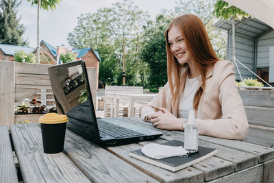 Businesswoman working on the laptop outdoors. businesswoman having video call, remote meeting while