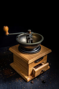 Close-up of old electric lamp on table against black background