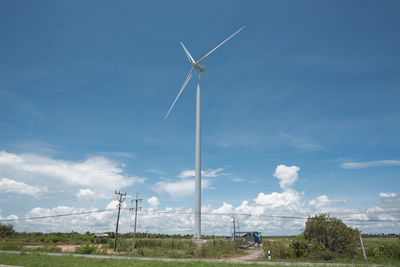 Low angle view of wind turbines against sky