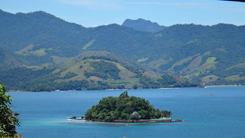 Scenic view of island and sea against mountains