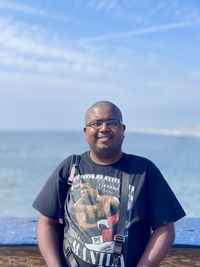 Portrait of young man standing at beach