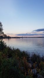 Scenic view of lake against clear sky at sunset