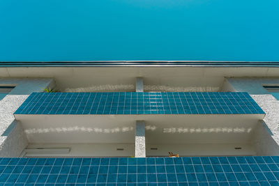 Low angle view of swimming pool against blue wall