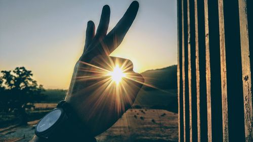 Optical illusion of man holding sun during sunset