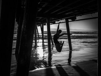 Reflection of man in water at beach