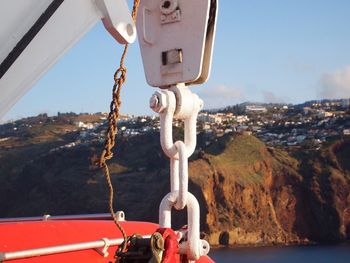 Close-up of boat sailing on sea against sky