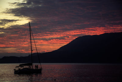 Silhouette sailboats in sea against sky during sunset