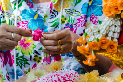 Midsection of woman making decoration with artificial flowers