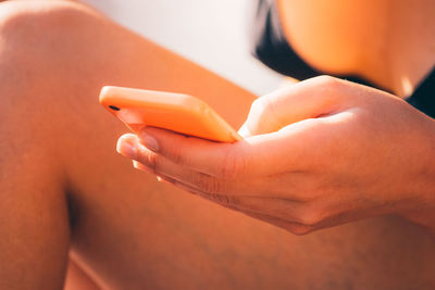 Midsection of woman holding mobile phone