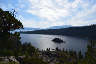 Scenic view of lake by trees against sky