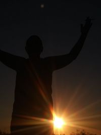 Rear view of silhouette person standing against sky during sunset