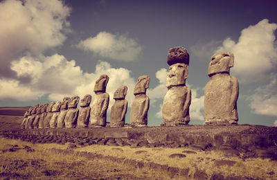 Low angle view of statues on wall against sky