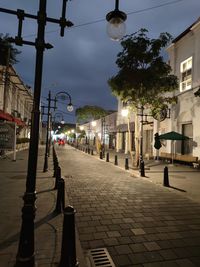 Street lights on sidewalk by buildings in city