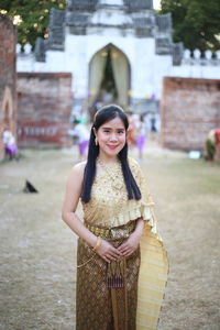 Portrait of smiling woman wearing traditional clothing standing outdoors