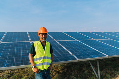 Portrait of engineer standing by solar panel
