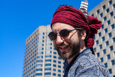 Portrait of man wearing sunglasses against blue sky