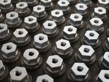 Metal hex bolts in the production, top view. fasteners manufacturing, industrial concept