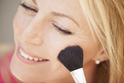 Close-up of woman applying make-up