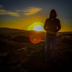 Man standing at desert during sunset