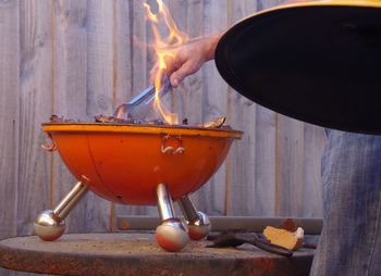 Man cooking meat in flames of barbecue grill