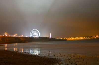 Illuminated ferris wheel at night