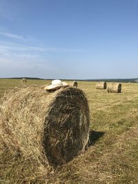 Hay bales on field against sky