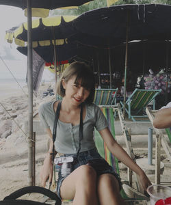 Young woman looking at while sitting on seat