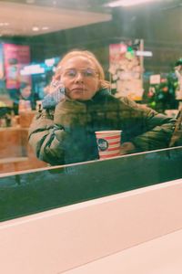 Portrait of woman against window