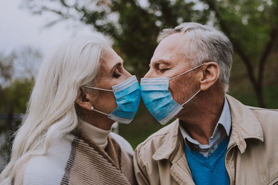 Portrait of friends with arms raised outdoors