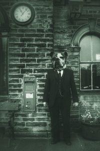 Full length of a man standing on brick wall