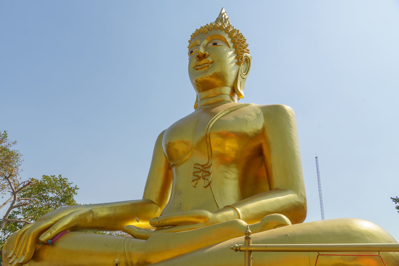 religion, statue, sculpture, belief, gold, spirituality, temple - building, human representation, male likeness, representation, architecture, culture, monument, no people, travel destinations, yellow, sky, clear sky, nature, travel, place of worship, building, outdoors, low angle view, built structure, temple, history, large, sitting, sunny, pagoda