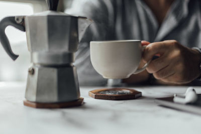 Midsection of man holding coffee