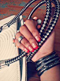 Cropped image of hand with nail paint holding handbag