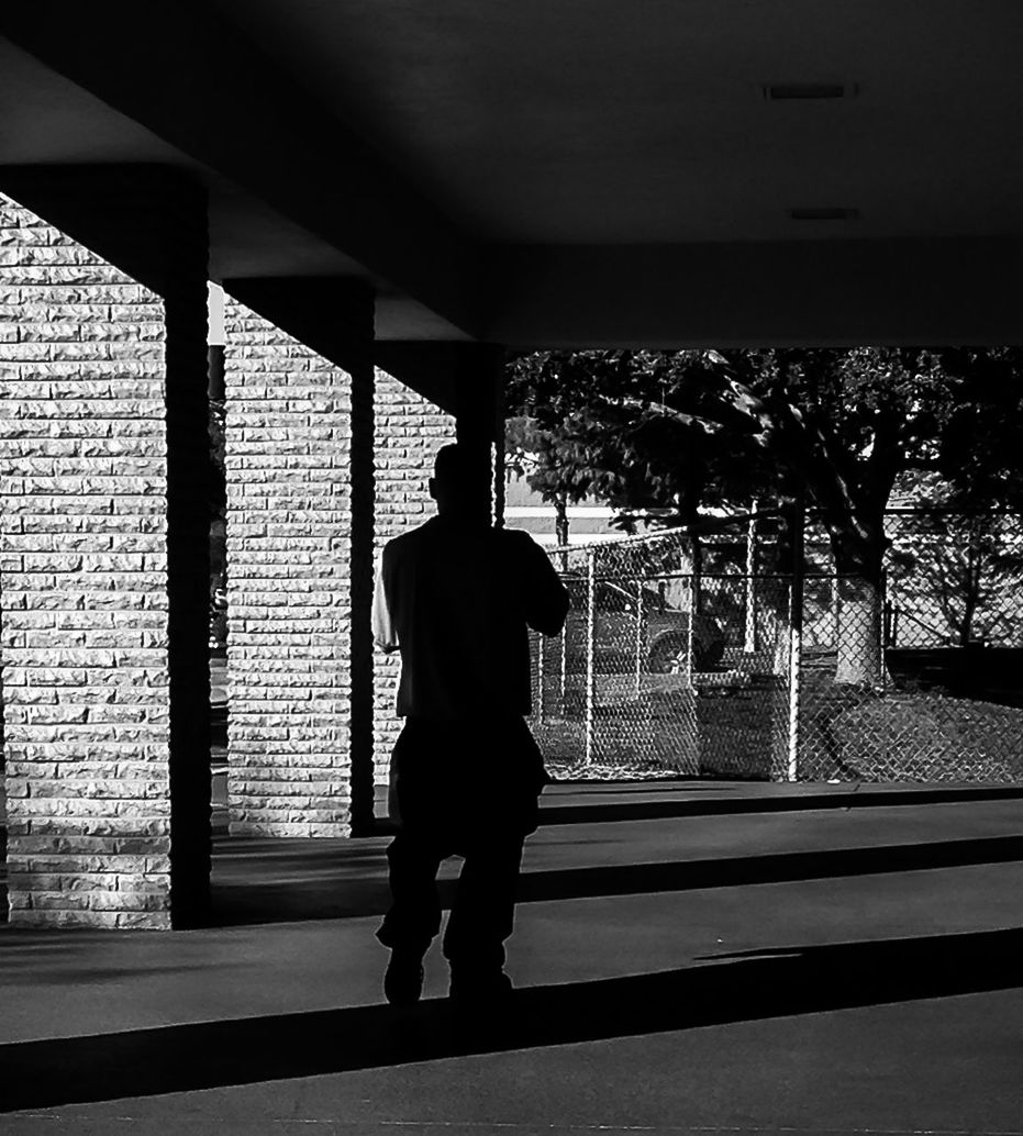 FULL LENGTH REAR VIEW OF SILHOUETTE MAN WALKING IN CORRIDOR