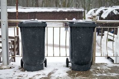 Grey garbage bins on street in winter. public trash containers on side of road. infectious control