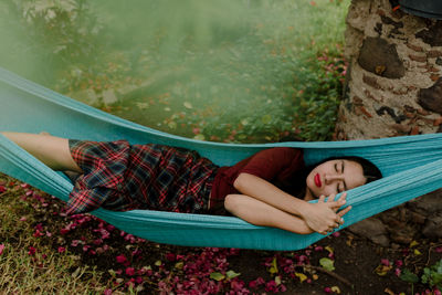 High angle view of woman sleeping in hammock