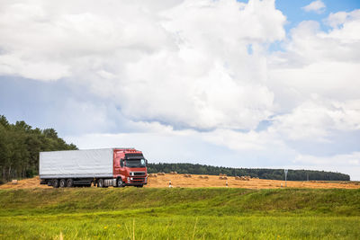 Truck on grassy field against sky