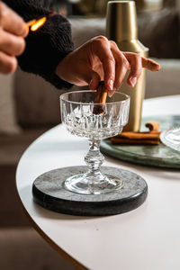 Close-up of hand holding wineglass on table