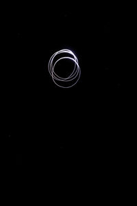 Low angle view of illuminated lighting equipment against black background