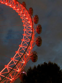 Low angle view of illuminated ferris wheel against sky at night