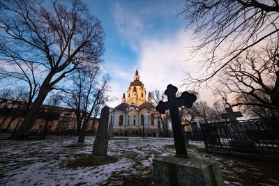 Church by building against sky during winter