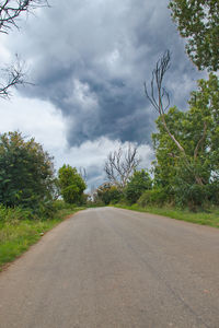 Road amidst trees against sky