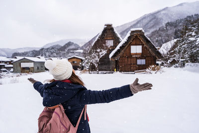 Rear view of woman on snowcapped mountain during winter