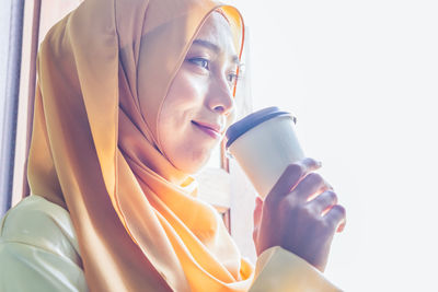 Portrait of young woman drinking coffee