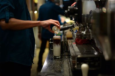 Cropped image of man preparing food at cafe